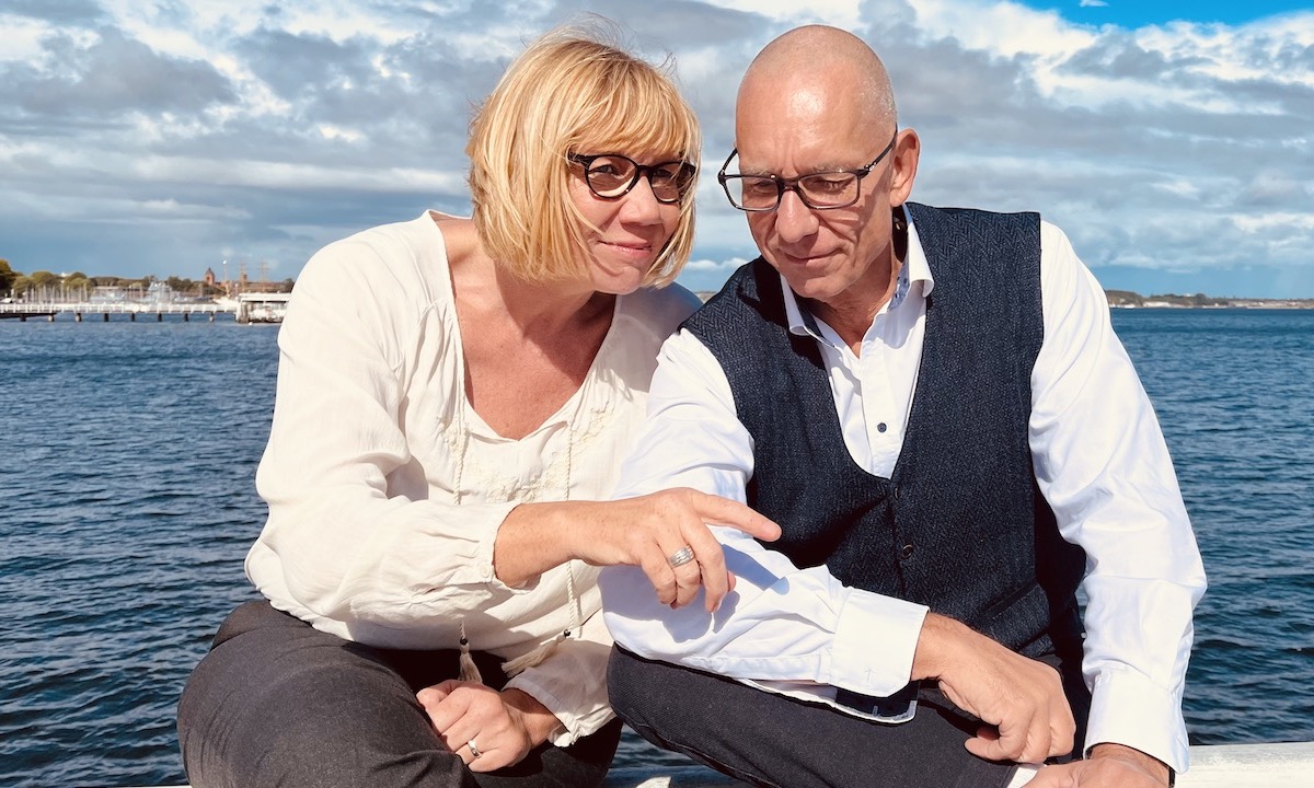 Das Team von keller ! consulting sitzt – sich miteinander unterhaltend – am Meer