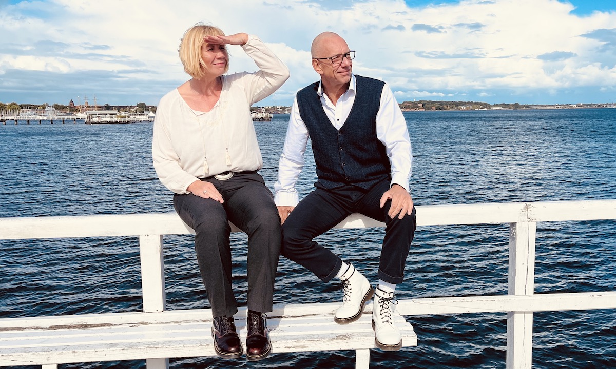 Das Team von keller ! consulting sitzt am Meer, beide schauen in die Ferne