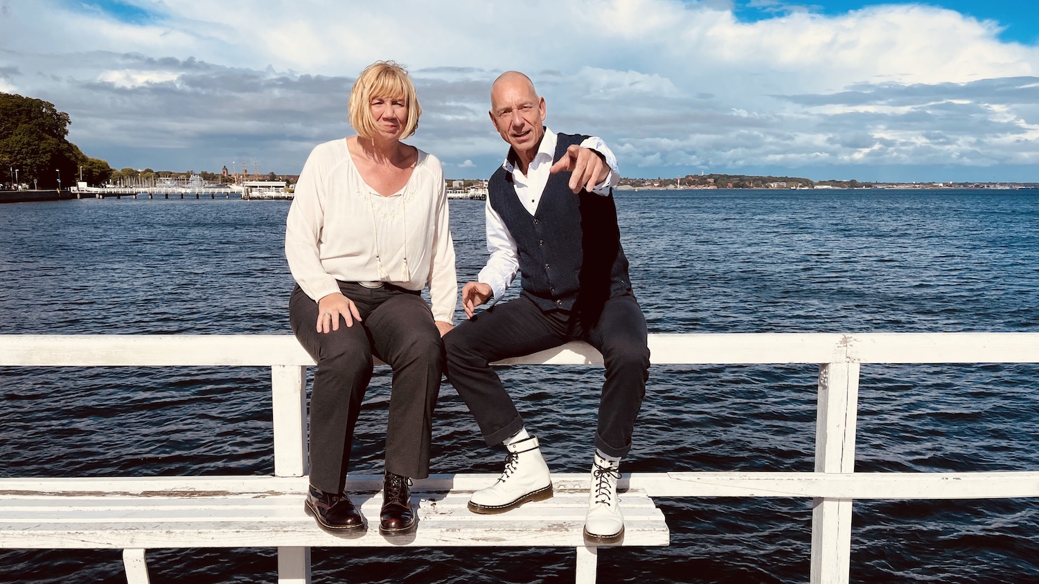 Das Team von keller ! consulting sitzt auf einem Steg am Meer und schaut nach vorn