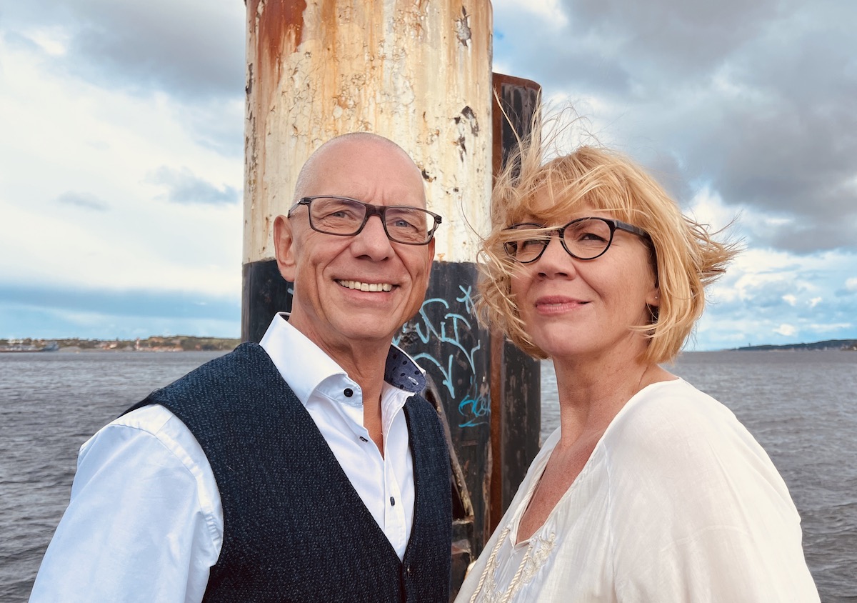 Das Team von keller ! consulting steht an einen Pfahl am Steg zum Meer